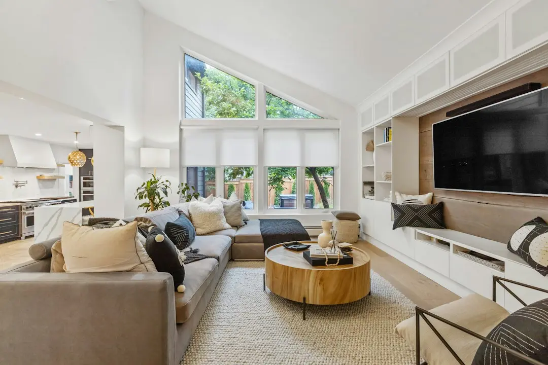 A bright living room with a large flat-screen TV set into a white wall unit, the kind of screen 4K IPTV is made for