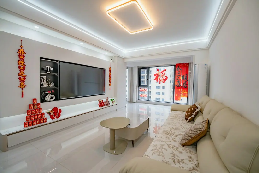 A bright living room with a wall-mounted TV and a cream sofa: the kind of room where Sapphire IPTV streams over the internet